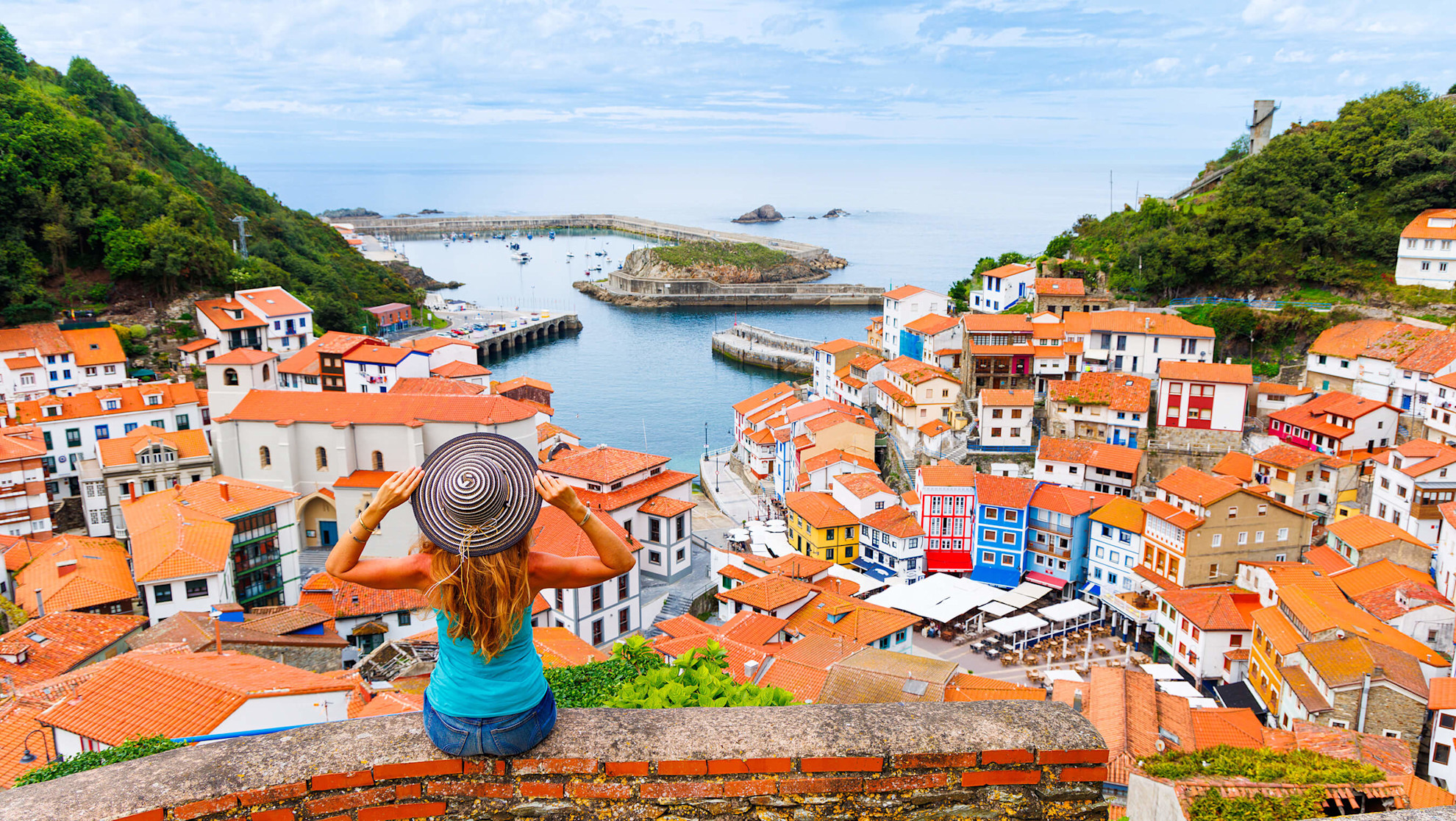 Woman tourist overlooking Cudillero, a fishing village in Asturias, Spain