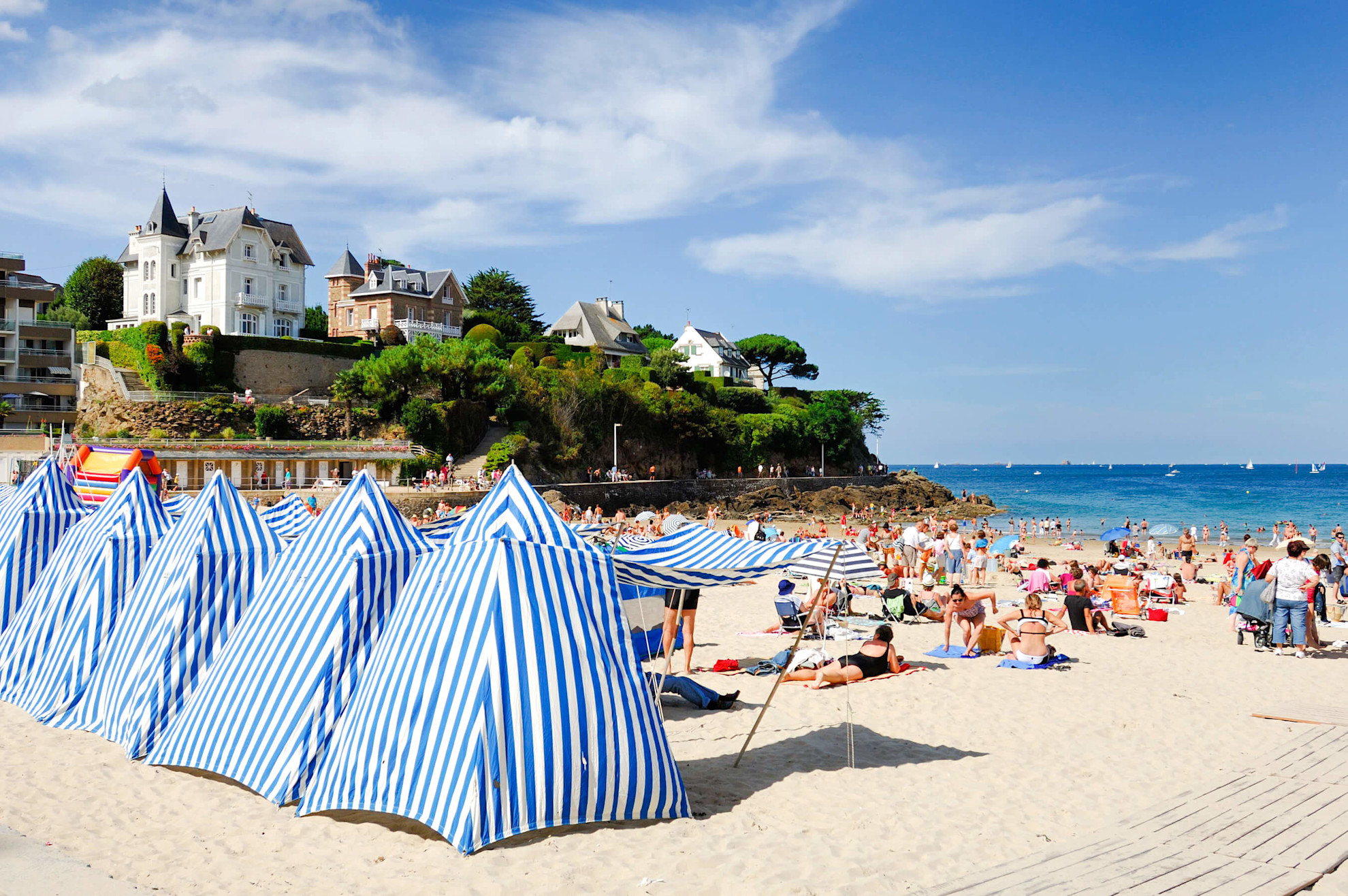 Blue and white beach huts at Dinard's Plage de l'Ecluse