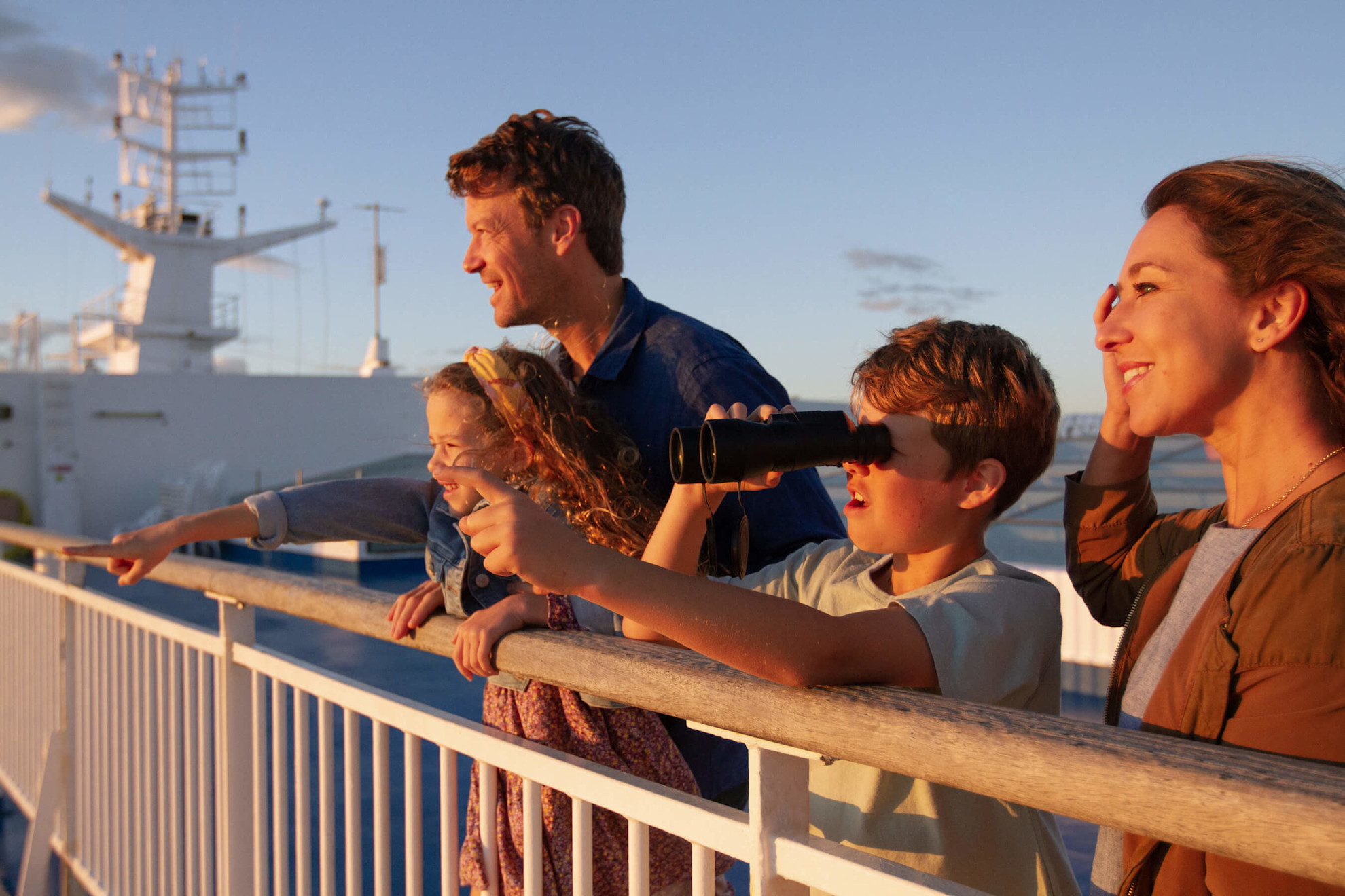 Family on deck at sunset enjoying the spectacular view
