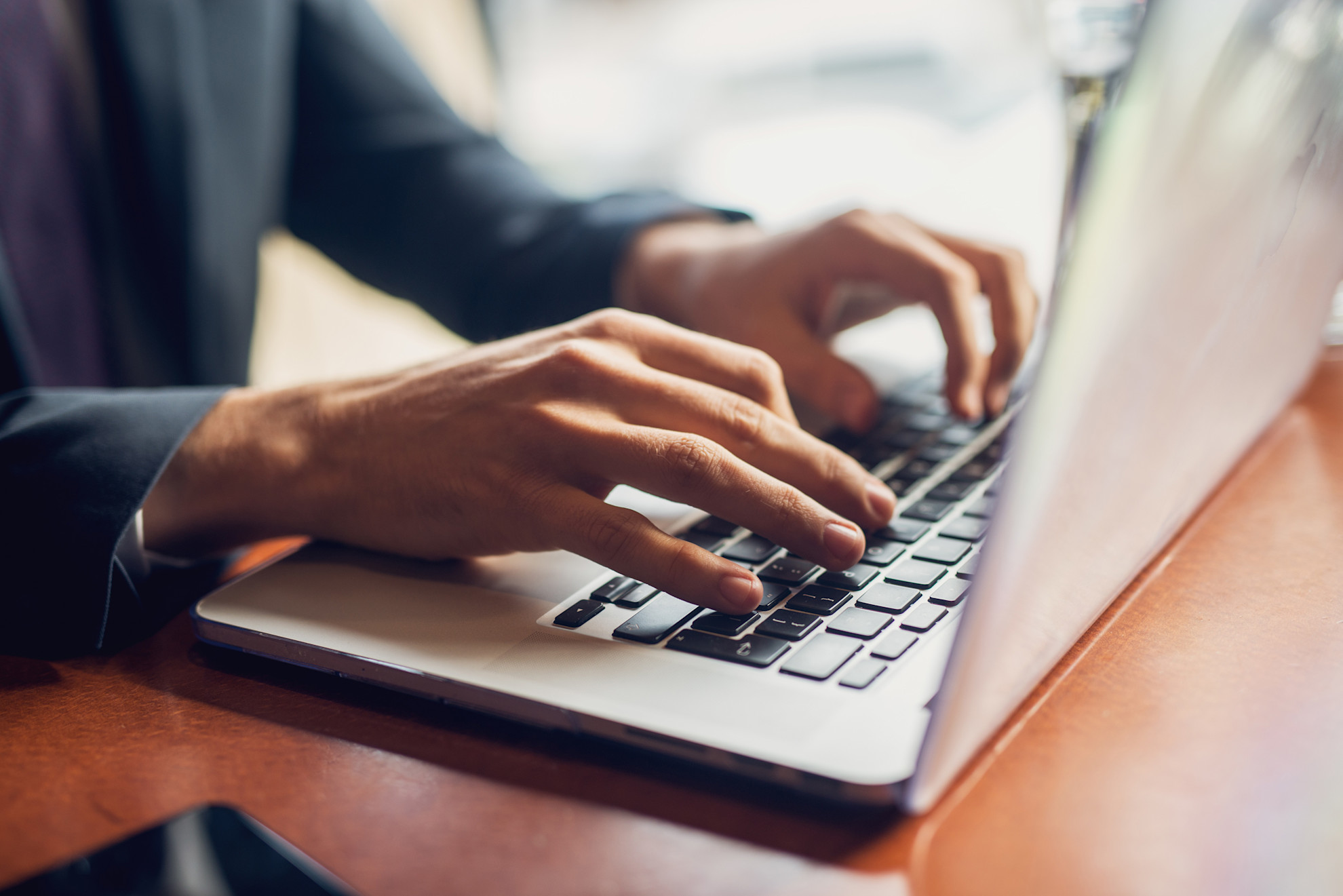 Hands on a laptop keyboard typing